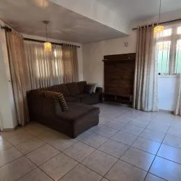 Foto de uma sala de estar com sofá e piso de cerâmica.