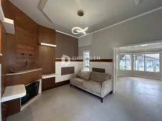 Sala de estar com painéis de madeira e sofá claro.
