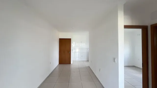 Corredor interno de uma residência com piso de cerâmica clara.