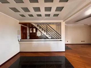 Foto de uma área interna com piso de madeira e escadaria.
