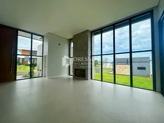 Sala de estar com grandes janelas que dão vista para o quintal.