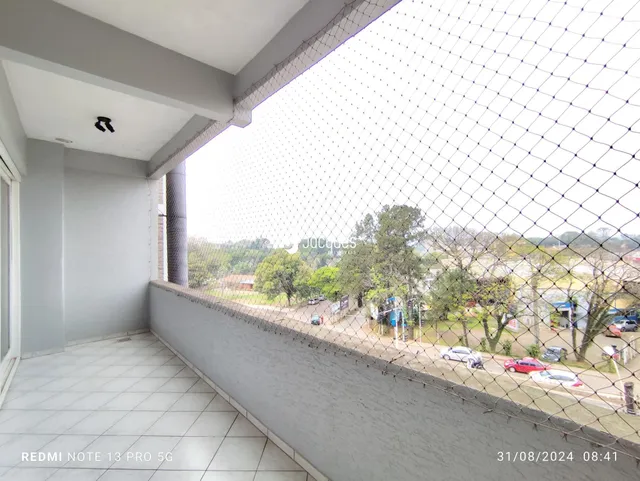 Vista de uma área interna com vista para o exterior através de uma cerca.