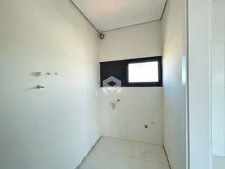 Hall de corredor interno com paredes brancas e piso claro.