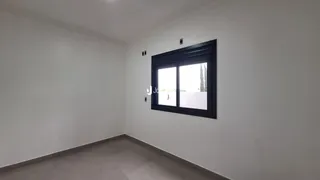 Parede branca com uma janela escura em um ambiente interno.
