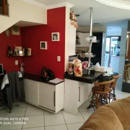 Foto interna de uma área de cozinha ou sala com paredes vermelhas e armário branco.