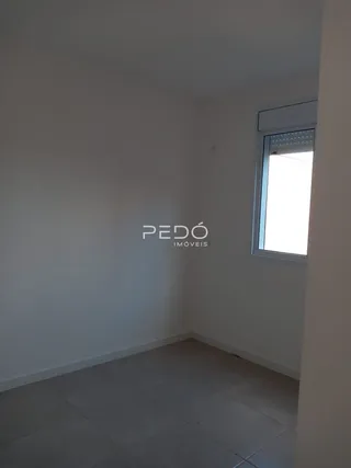 Ambiente interno de uma sala com parede branca e piso claro.