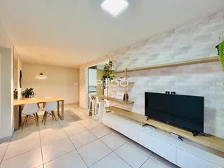 Ambiente de sala de estar e jantar com piso de cerâmica clara.