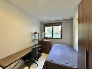 Quarto com janela e móveis de madeira no interior da residência.