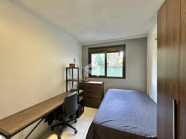 Quarto com janela e móveis de madeira no interior da residência.