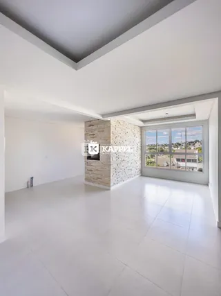 Uma sala ampla com piso claro e parede de pedra no interior de uma residência.