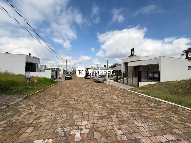 Vista externa de uma rua pavimentada com casas em Lajeado, Brasil.