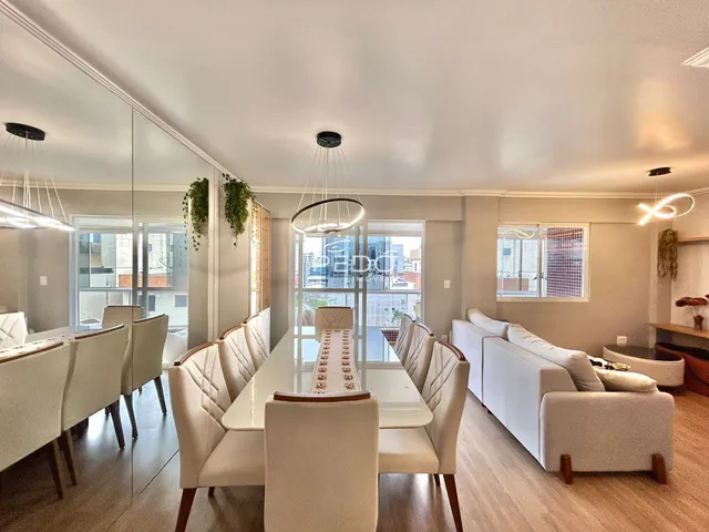 Vista da sala de jantar com mesa e cadeiras em um apartamento em Lajeado.