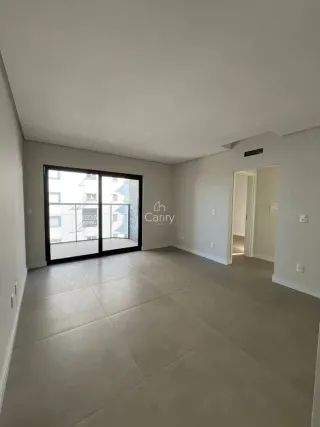 Sala de estar com piso claro e porta de vidro que dá acesso ao exterior.