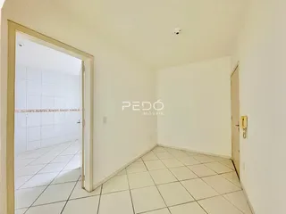 Hall de entrada com piso de cerâmica branca.