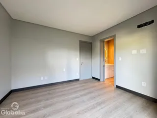 Vista de um ambiente interno com paredes cinzas e piso de madeira clara.