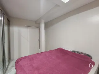 Quarto com cama de casal em ambiente interno.