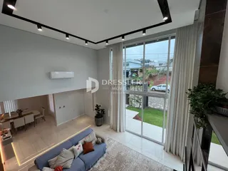 Sala de estar moderna com grandes janelas de vidro.