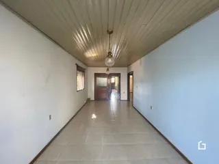 Corredor interno de uma residência com piso de cerâmica e paredes brancas.