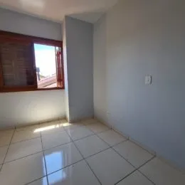 Vista interna de um cômodo com piso de cerâmica e janela.