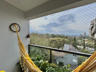 Vista panorâmica de uma paisagem verde com casas ao fundo.