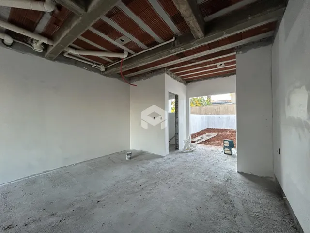 Interior de um ambiente com teto de concreto aparente e paredes brancas.