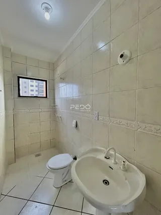 Foto de um banheiro com revestimento de azulejos brancos.