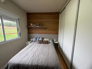 Quarto com cama grande e parede de madeira.