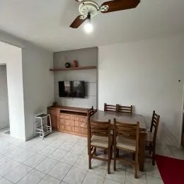 Quarto com cabeceira de madeira e televisão na parede.