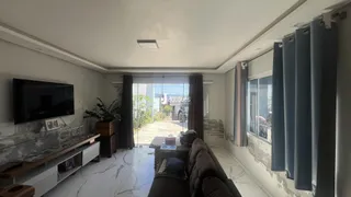 Sala de estar com grandes janelas que dão para o exterior.