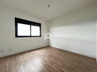 Foto de um ambiente interno com piso de madeira clara e janela grande.