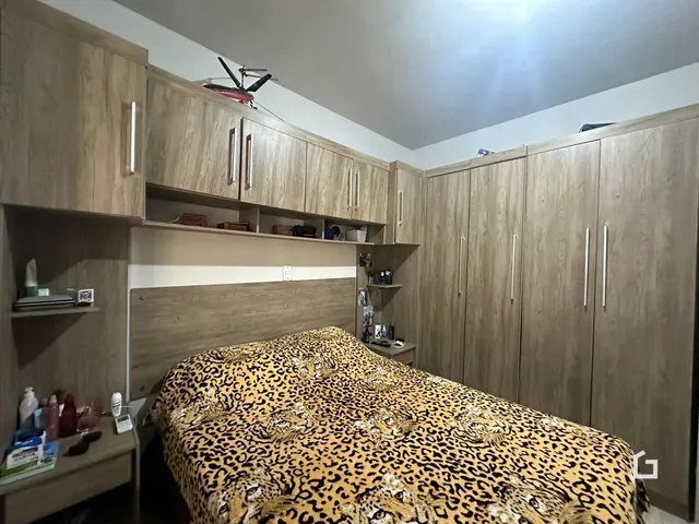 Quarto com armários em madeira e cabeceira de madeira.