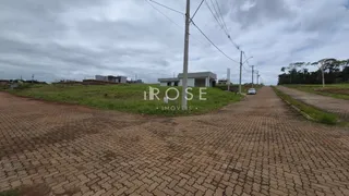 Vista externa de uma propriedade com área pavimentada e vegetação ao redor.