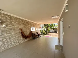Sala de estar com parede de pedra e móveis de vime.