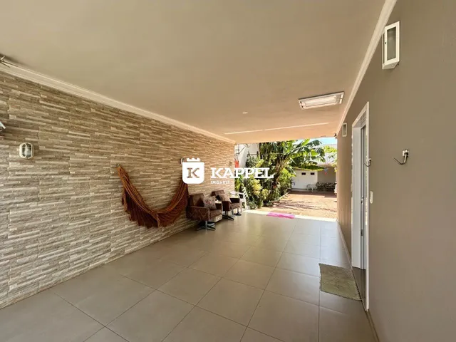 Sala de estar com parede de pedra e móveis de vime.