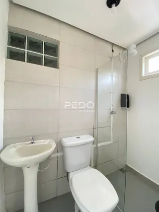 Foto de um banheiro com azulejos brancos e box de vidro.