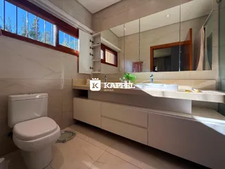 Banheiro com bancada de mármore e janela ampla.