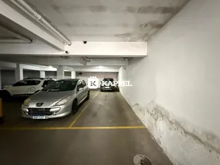 Vista de um corredor de estacionamento com veículos estacionados.