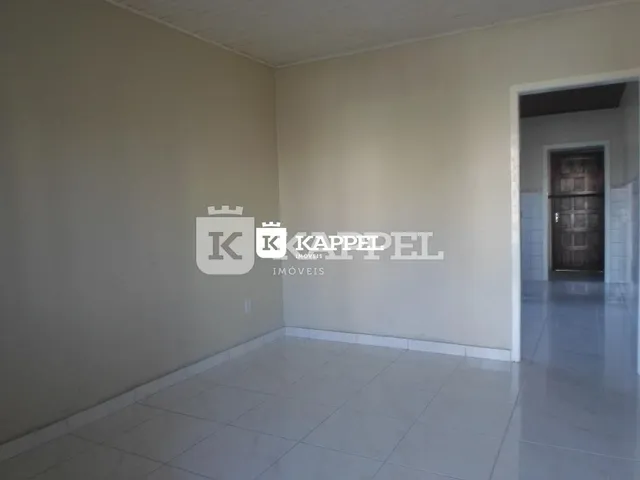 Vista interna de um ambiente com paredes brancas e piso claro.