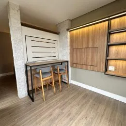 Sala de estar com piso de madeira e painel de madeira na residência.