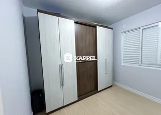 Quarto com armários embutidos e piso de madeira clara.