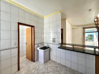 Interior de uma cozinha com revestimento de cerâmica e portas de madeira.