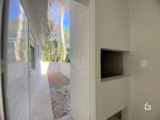 Vista de um corredor interno com acesso a um pátio externo no imóvel.