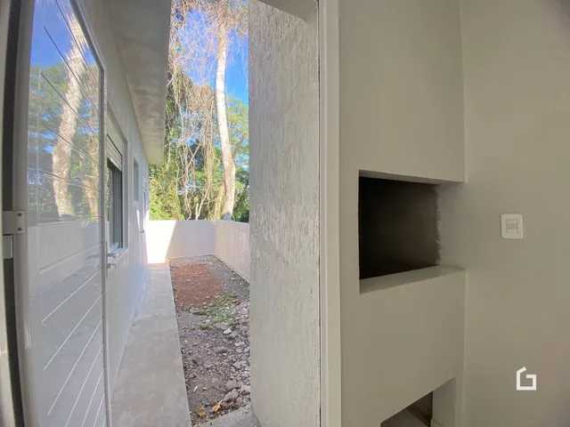 Vista de um corredor interno com acesso a um pátio externo no imóvel.