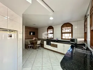 Ambiente aberto com cozinha e sala de jantar em um imóvel no Brasil.