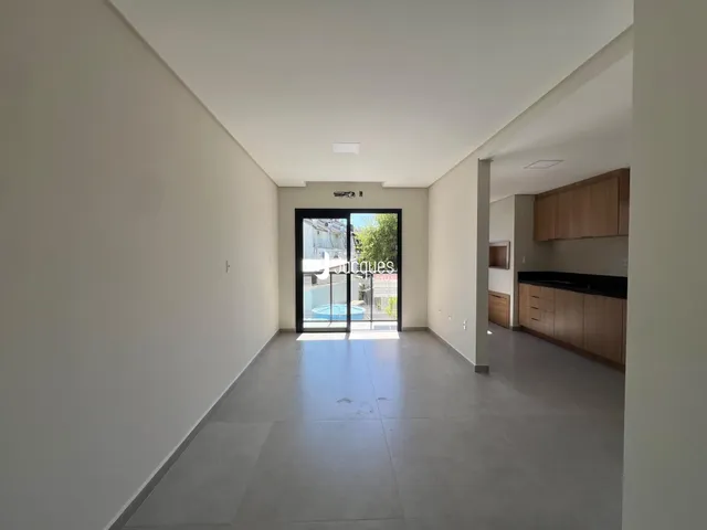 Hall de entrada com piso claro e paredes brancas em imóvel em Lajeado.