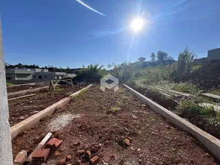 Vista de um terreno em Lajeado, Brasil, com delimitações de concreto e vegetação rasteira.