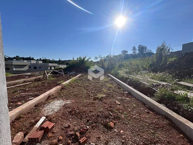 Vista de um terreno em Lajeado, Brasil, com delimitações de concreto e vegetação rasteira.