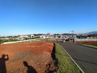 Vista externa de um terreno com terra e estrada no Brasil.