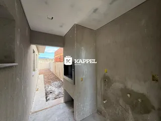 Hall de entrada com paredes de concreto aparente em uma estrutura em construção.