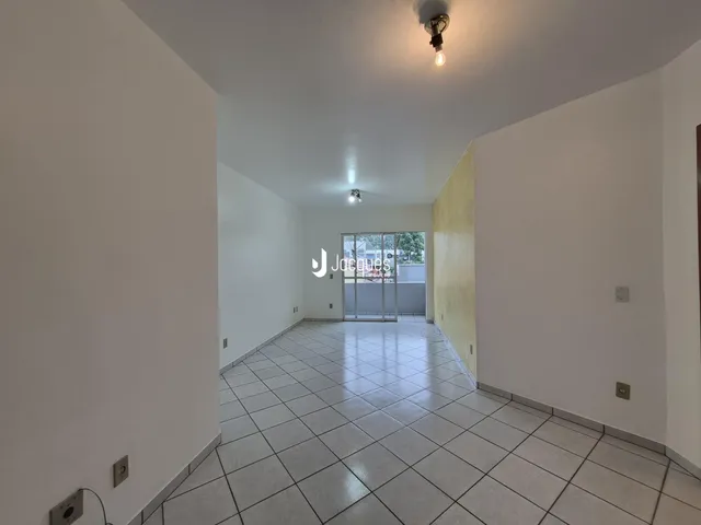 Corredor interno com piso de cerâmica claro.